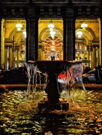 Water fountain in illuminated building at night