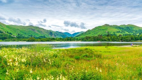 Scenic view of lake by mountains against sky