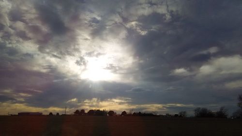 Silhouette field against sky during sunset