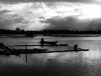 Boats in sea against cloudy sky