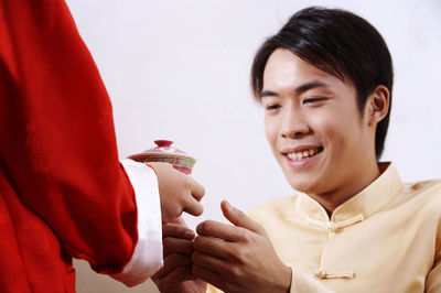 Midsection of boy giving drink for father