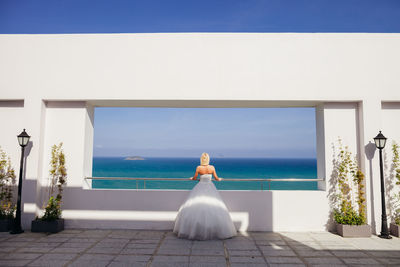 Rear view of bride standing against sea