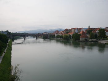 Bridge over river against buildings in city