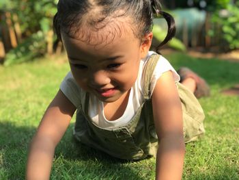 Close-up of cute smiling girl playing on grass in park