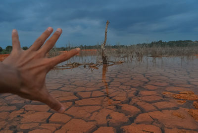 Close-up of hand against water