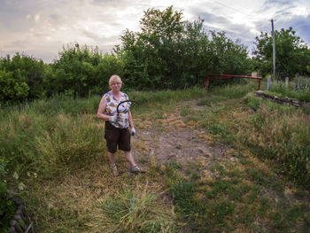 Full length of boy on grassy field against sky
