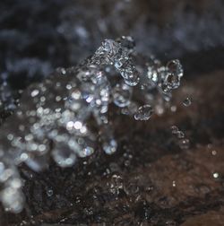 Close-up of water drops spewing over a rock