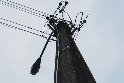 Low angle view of electricity pylon against sky