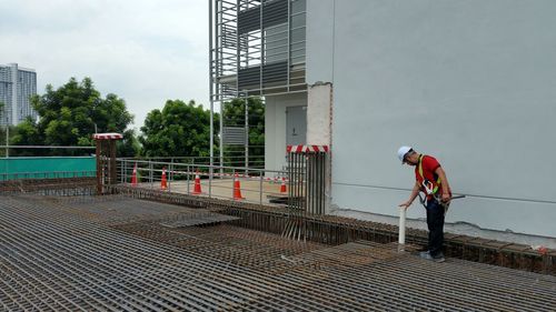 Construction worker checking at site against building