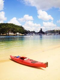 Boat moored on shore against sky