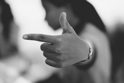 Side view of woman hand pointing outdoors