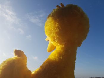 Low angle view of yellow sculpture against sky