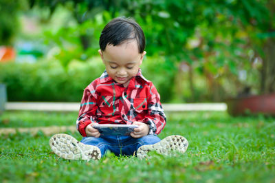 Cute boy sitting in grass