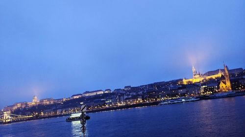 Illuminated buildings in city at waterfront