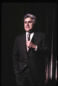 Portrait of mature man standing against black background