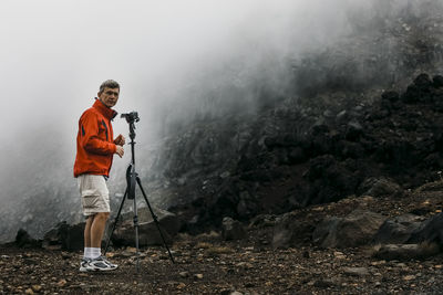 Man standing on rock by mountain