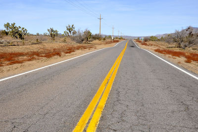 Country road in desert against sky