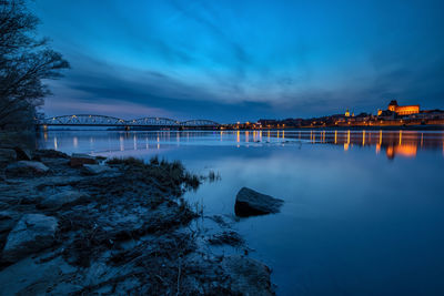 Bridge over river against sky at sunset