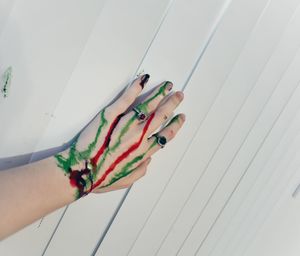 Christmas colored dye stained hand against blinds