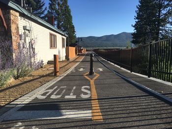 Bollard on road against clear blue sky