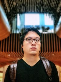 Portrait of young man wearing eyeglasses at home