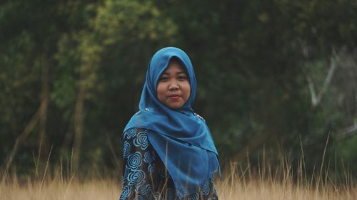 Portrait of woman in hijab standing on field