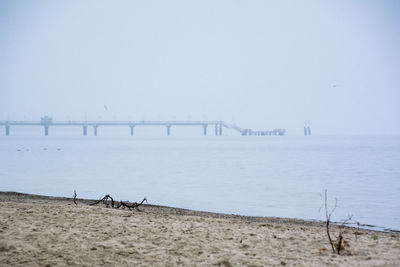 Pier over sea against sky during foggy weather