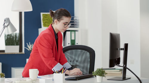 Side view of young businesswoman working at office