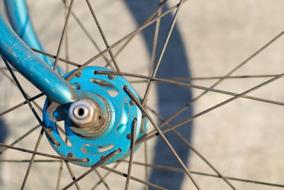 Close-up of blue bicycle front wheel hub and spokes