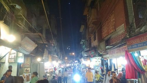 People walking in illuminated city at night