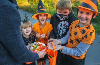 Midsection of man giving candies to kids