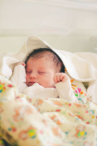 Portrait of cute baby boy sleeping on bed at home