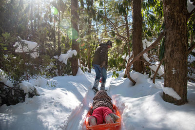 Rear view of man walking on snow covered land