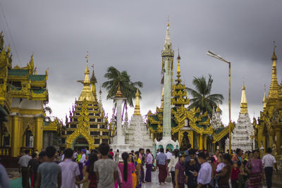 People at temple against sky