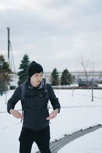 Full length of woman standing in snow against sky