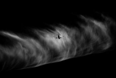 Low angle view of silhouette airplane against sky