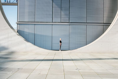 Woman standing on circle against building