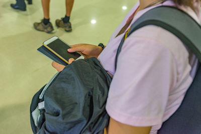 Midsection of woman holding mobile phone