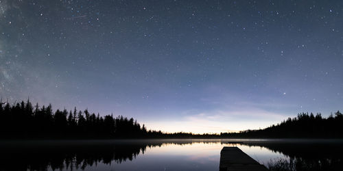 Scenic view of lake against sky at night