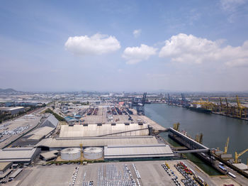 High angle view of cityscape by river against sky