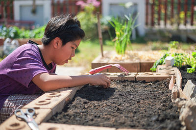Side view of boy gardening outdoors