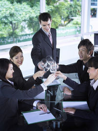 Smiling colleagues with drinks at restaurant during meeting