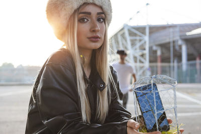 Portrait of young woman looking away against sky