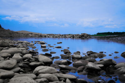 Rocks in sea against sky