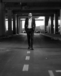 Portrait of man walking on road in parking lot