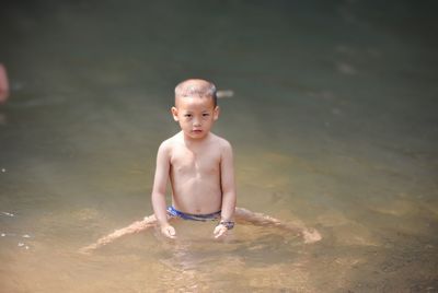 Portrait of shirtless boy in water