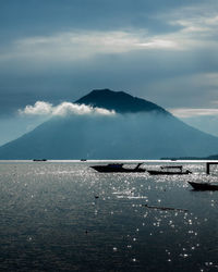 Scenic view of sea and mountains against sky