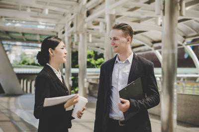 Confident business people talking while standing outdoors