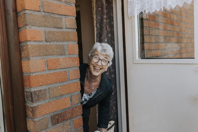 Senior woman looking through open door