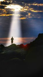 Man on beach against sky at sunset